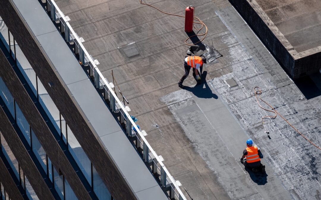 Birds eye view of a roof construction site. Professional bitumen waterproofing on a flat building.