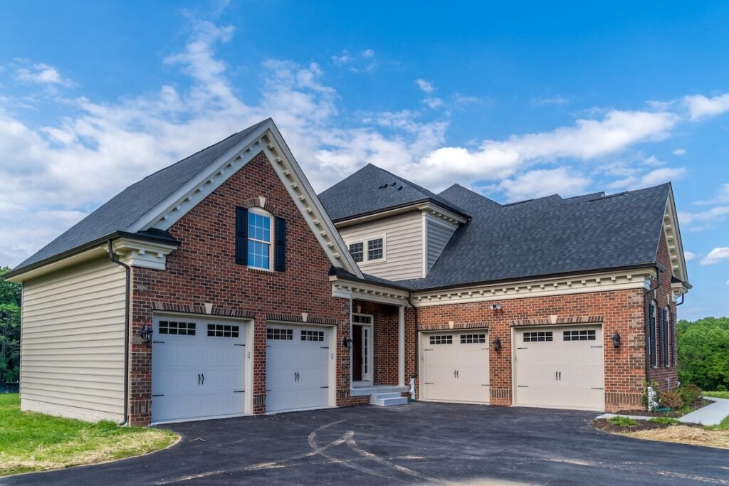 Four car garage with brick siding as part of an American real estate mansion certainteed vs gaf