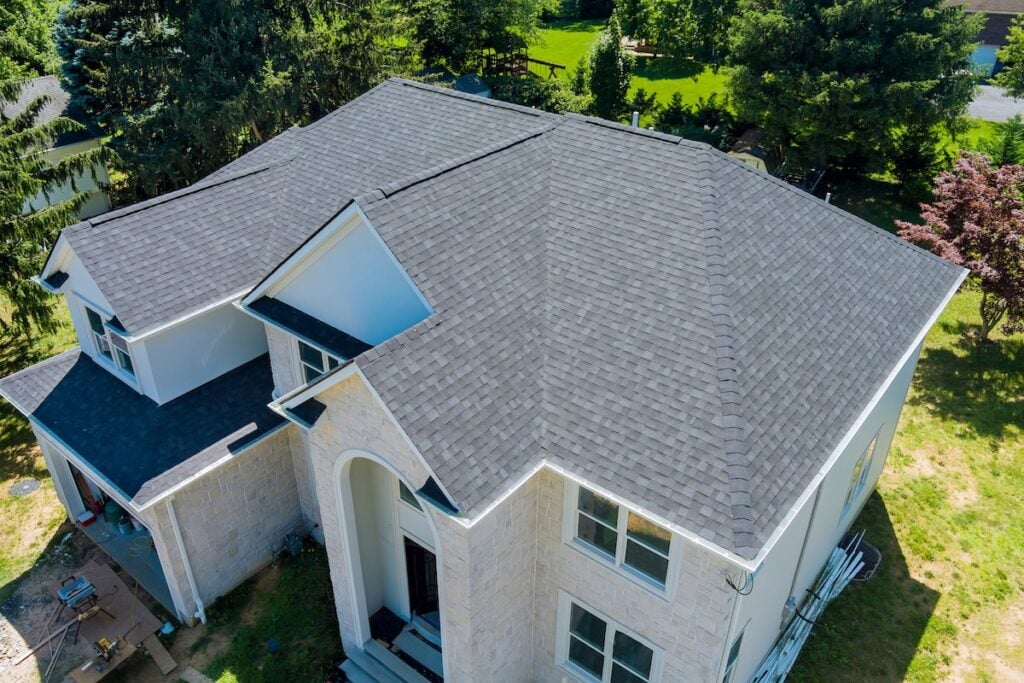 Aerial view of asphalt shingles construction site roofing the house with new window roof inspection cost