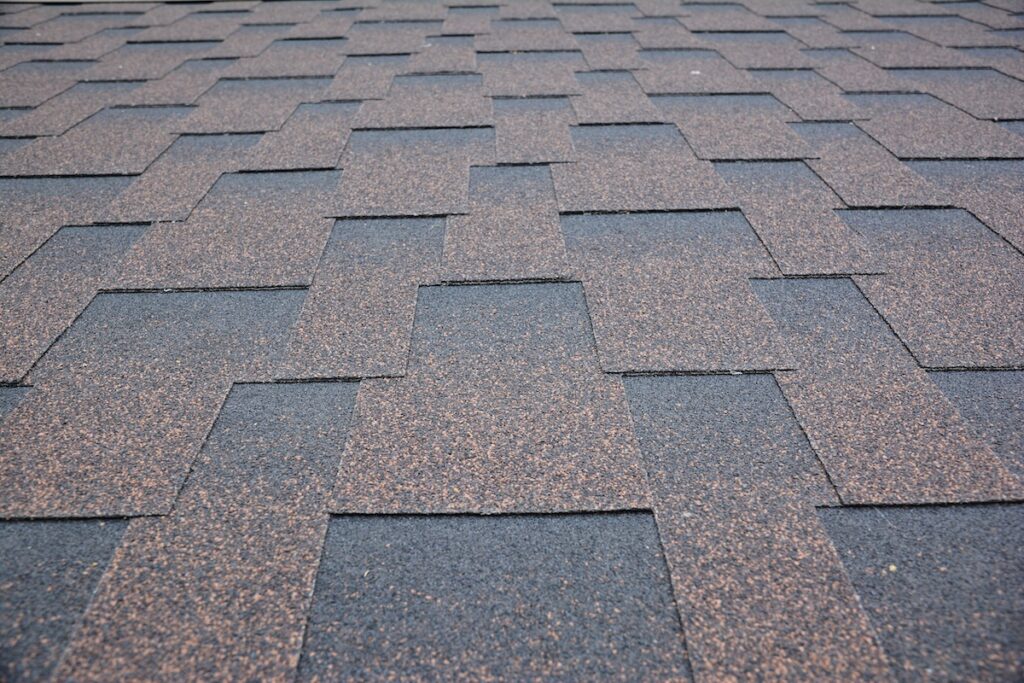 certainteed landmark shingles Copper brown roofing asphalt shingles texture background. A close-up of an asphalt laminated, dimensional, or architectural shingled roof. Asphalt shingles roofing construction.
