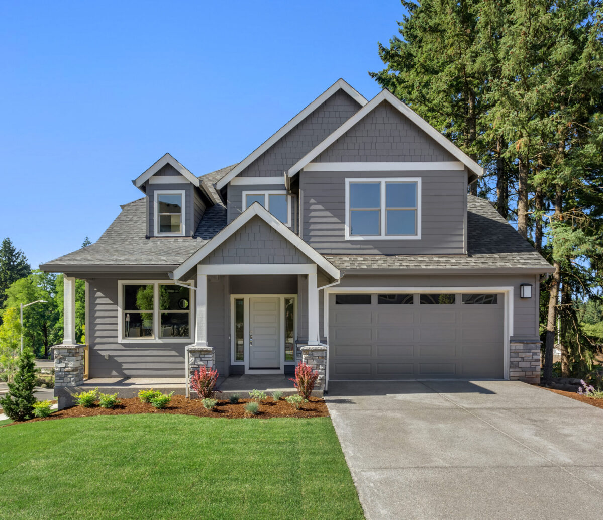 Suburban home exterior on bright sunny day, with large yard and