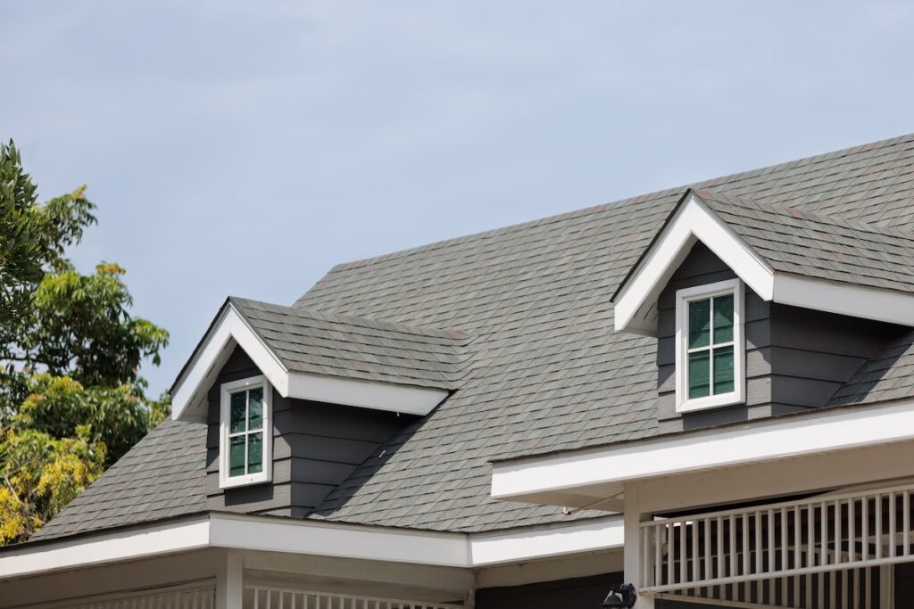 how to measure a roof for shingles Roof shingles with garret house on top of the house. dark asphalt tiles on the roof background on afternoon time. dark asphalt tiles on the roof background