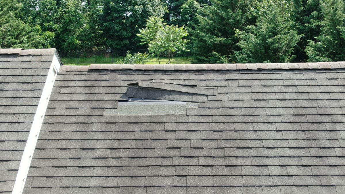 missing shingles falling after wind storm charcoal grey roof family house