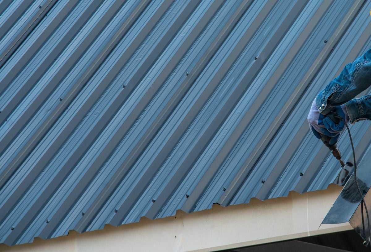 Construction worker wearing safety harness belt during working on roof structure