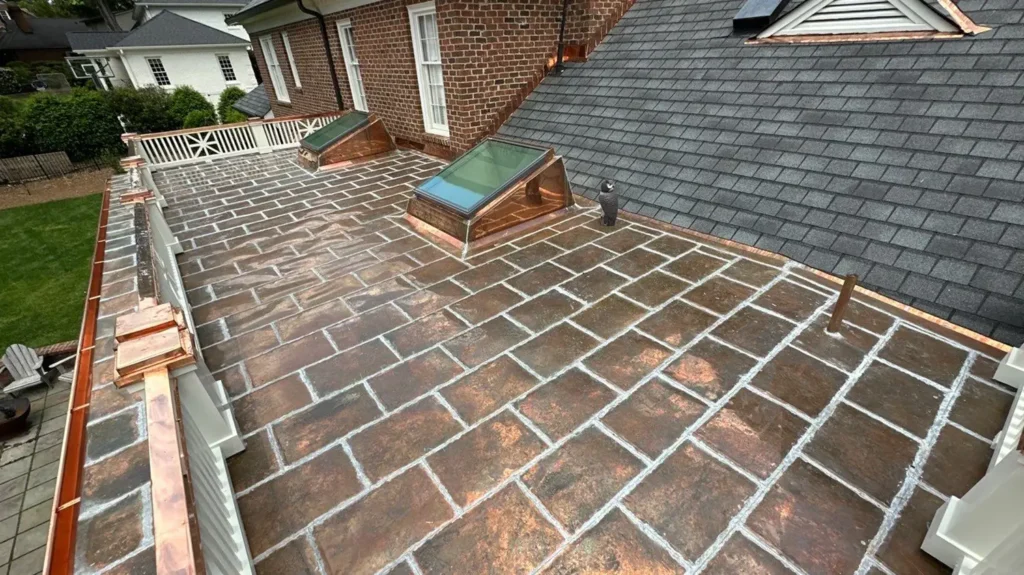 A flat roof terrace featuring GAF Slateline roof replacement, two skylights with copper flashing, and a decorative owl figurine.