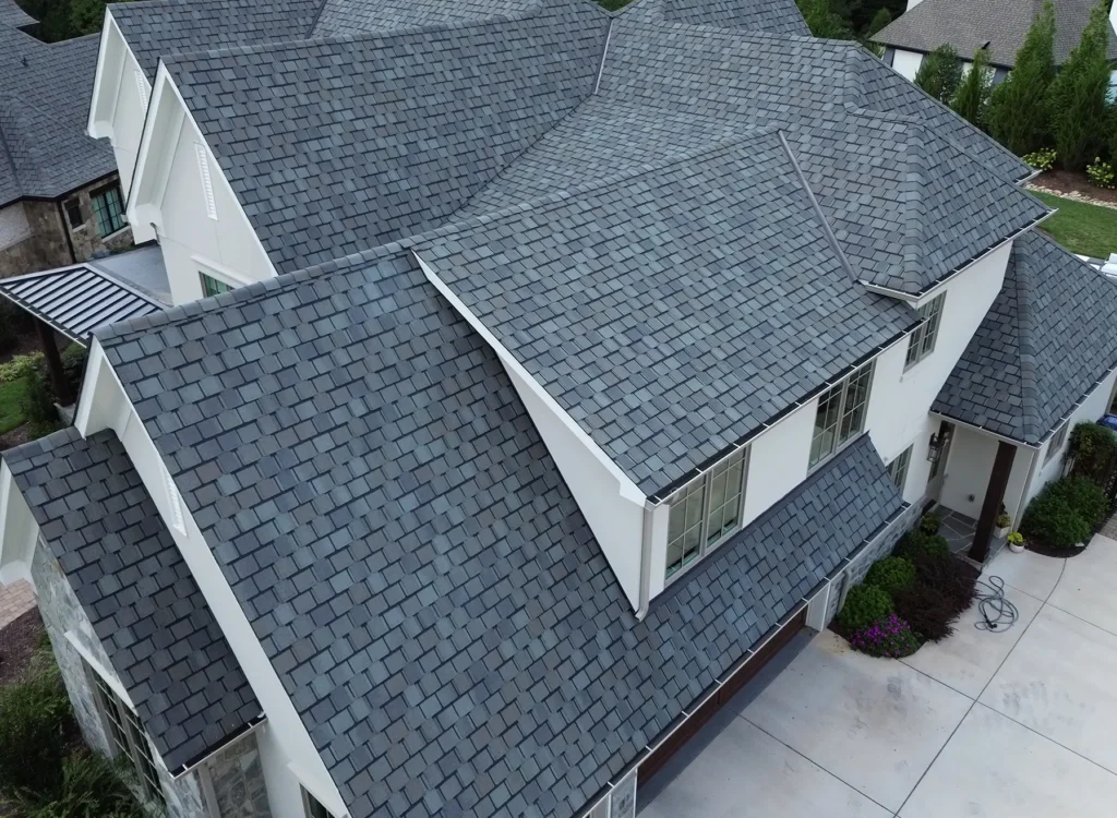 Aerial view of a large house with CertainTeed Belmont shingles, white exterior walls, large windows, and surrounding greenery—perfect for Waxhaw NC roof installation inspiration.