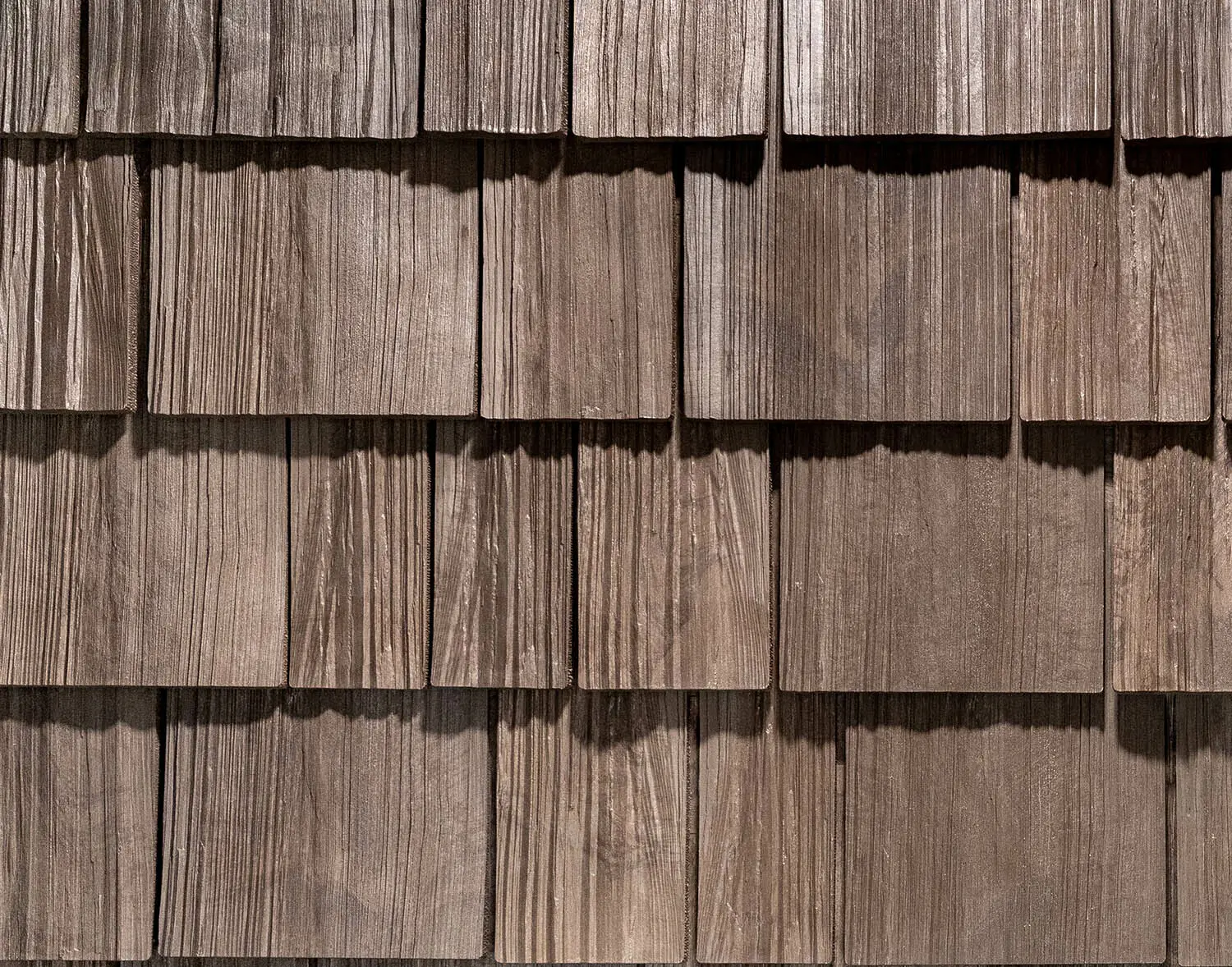 Overlapping brown wooden shingles on a Brava composite roofing system.